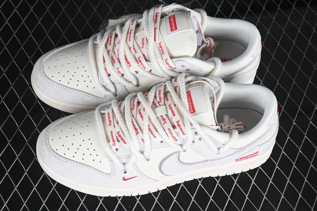 Pair of white and light gray sneakers with red details