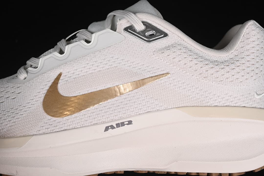 Close-up of the mesh-patterned upper, gold-tone Swoosh and midsole branding.