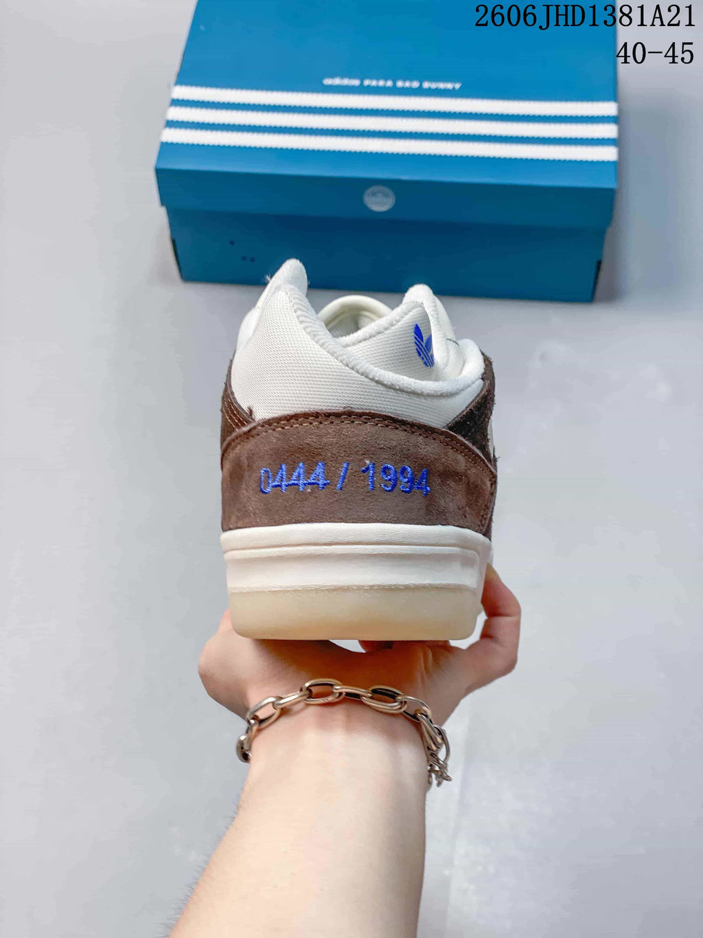 Rear view showing the brown heel panel embroidered “DA444 / 1994,” with a blue Adidas x Bad Bunny box behind; image overlay shows 40–45.