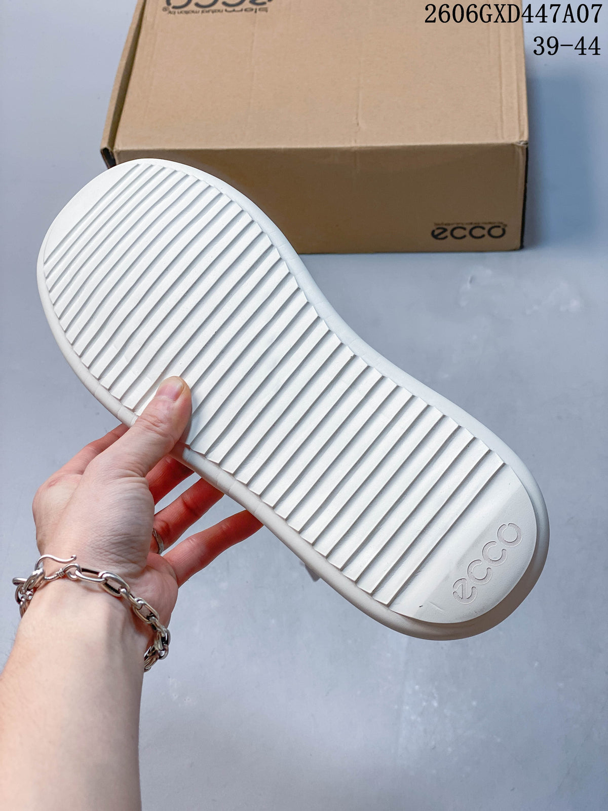 Underside of the white sneaker showing a ridged outsole