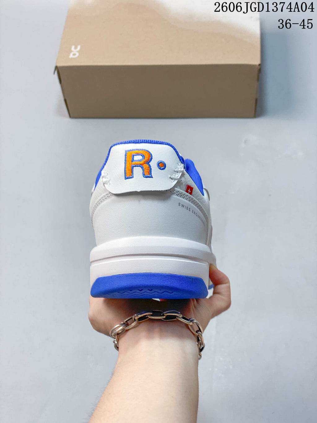 Rear view of the sneaker with a white heel, blue trim, and orange logo detail