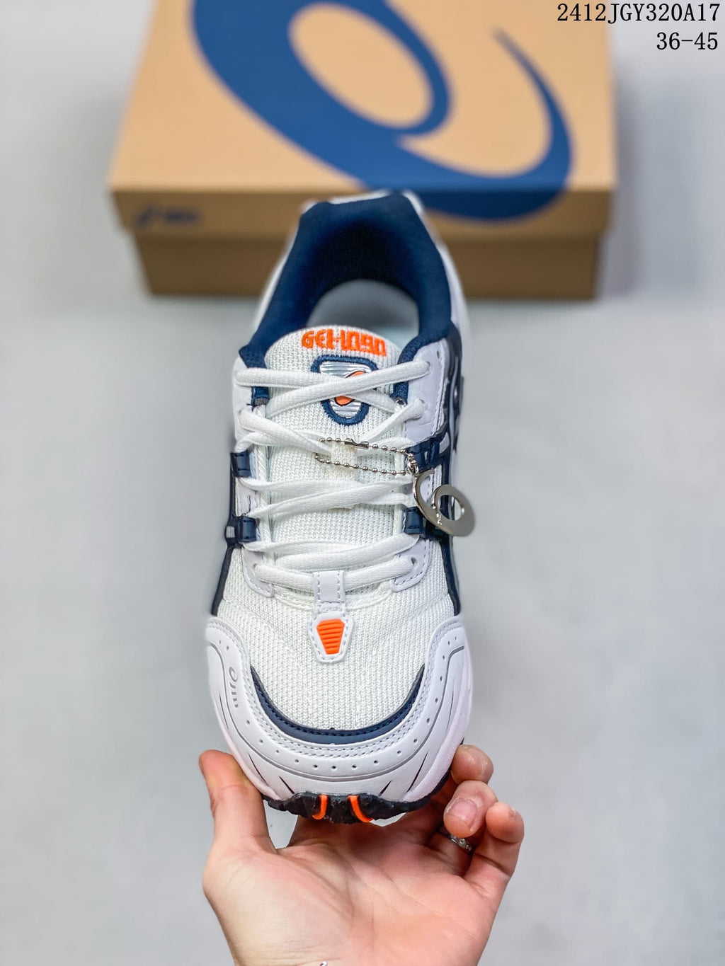 Front view of the white ASICS GEL-1090 sneaker with navy and orange details