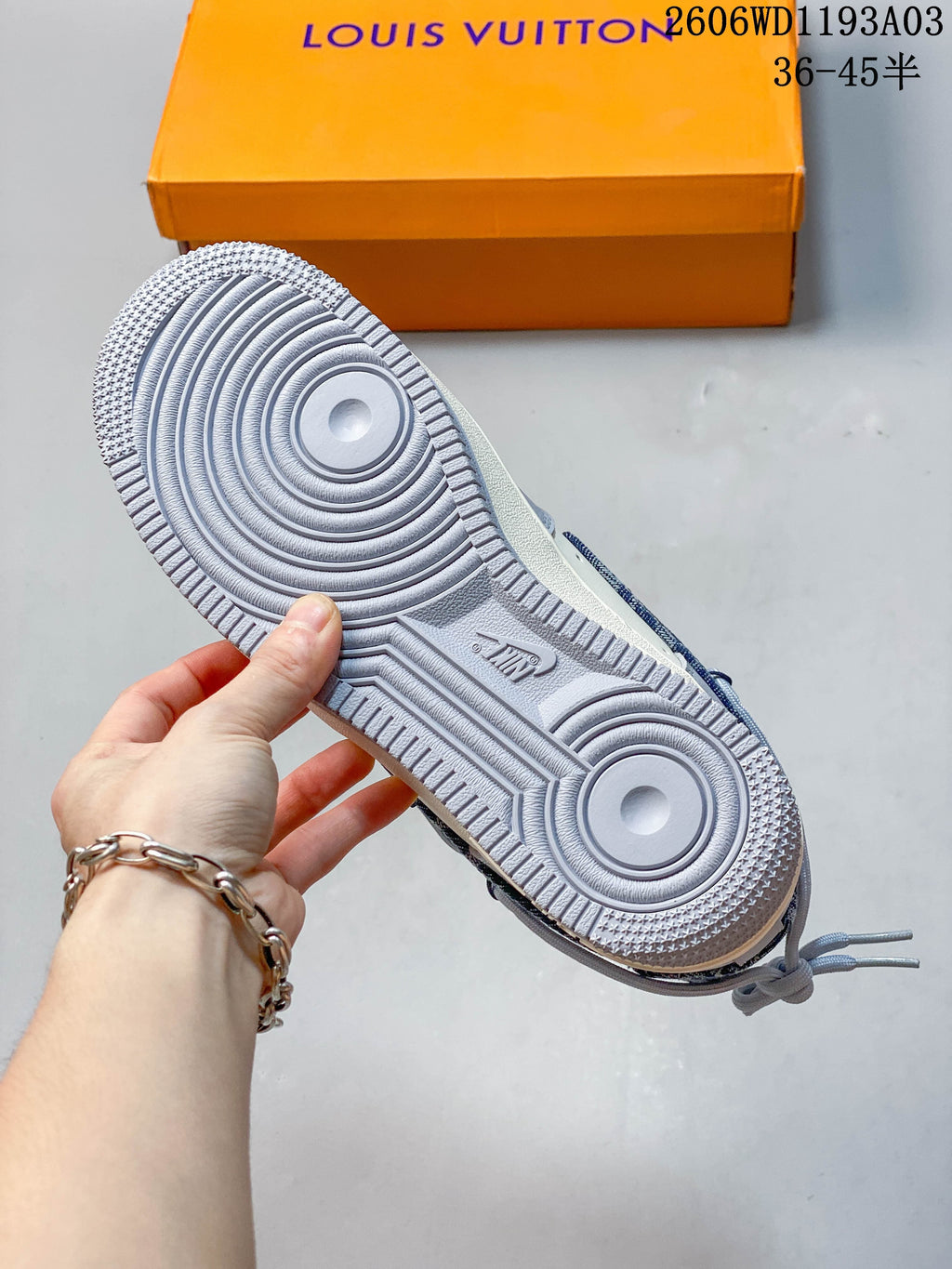 Close-up of the sneaker outsole with concentric circular tread, with an orange branded box in the background.