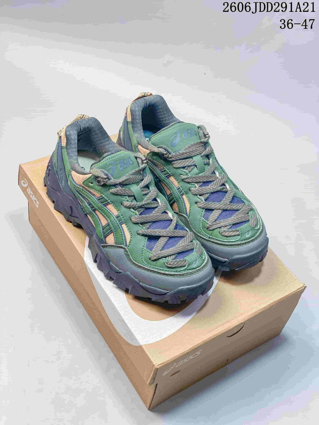 Pair of green, blue-gray, and tan ASICS Gel-Pickax sneakers on a shoebox