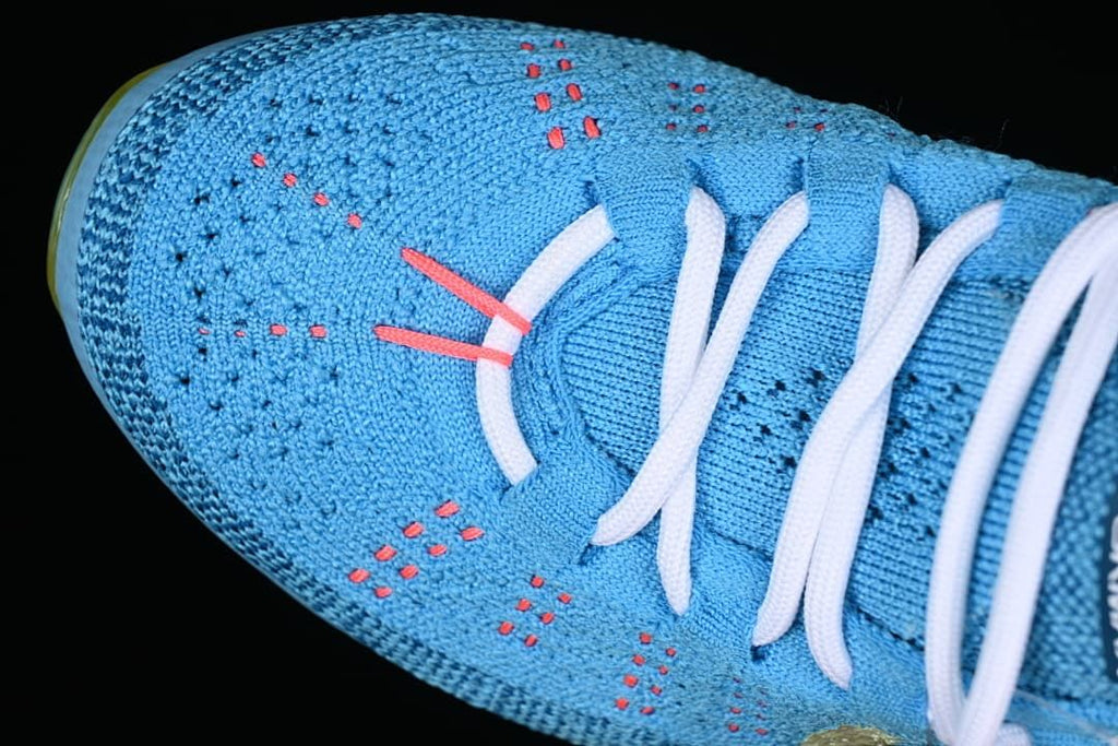 Top view of the knit toe, coral accents and white laces.
