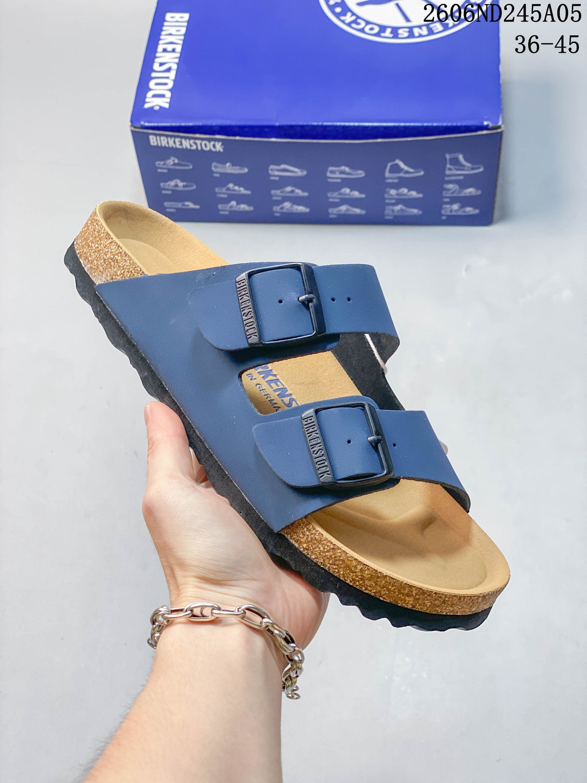 Angled view of the blue two-strap sandal with adjustable buckles and contoured footbed.