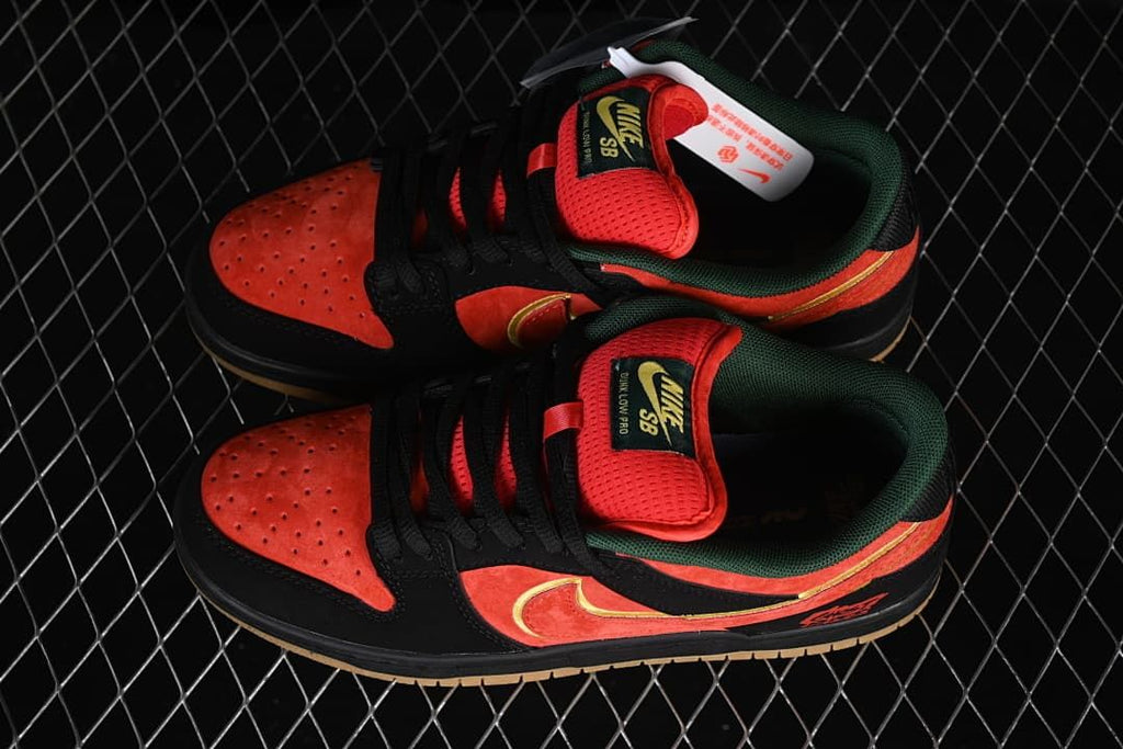 Pair of red-orange and black Nike SB Dunk Low sneakers shown from above and the side.