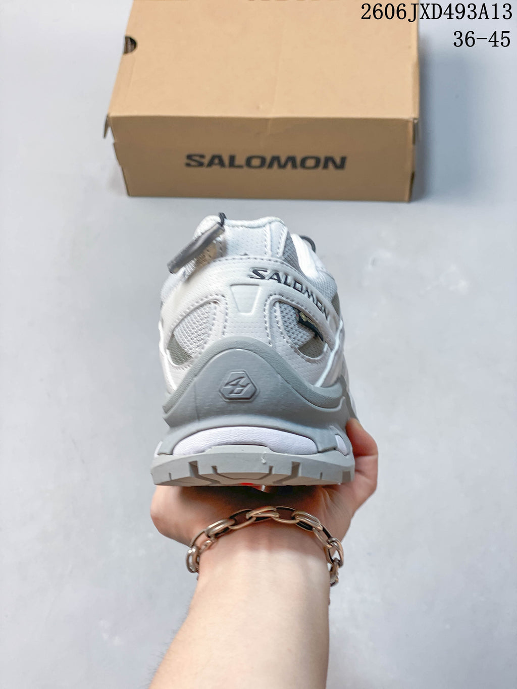 Rear view of the white and grey sneaker showing the heel and outsole.