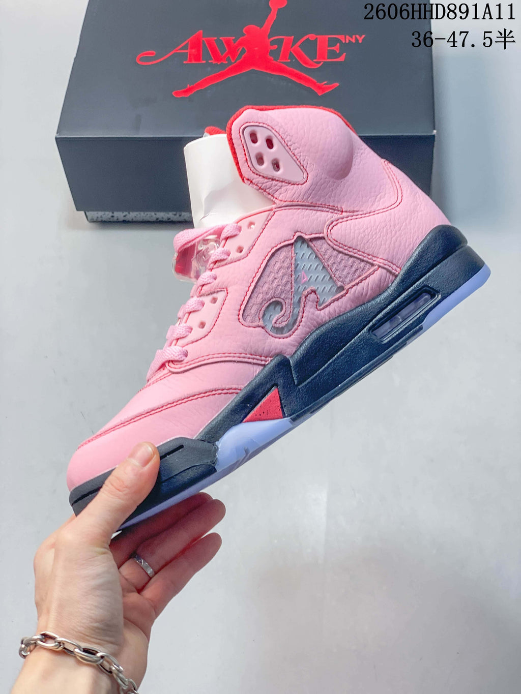 Side view of the pink mid-top sneaker with side panel detailing and a dark midsole.