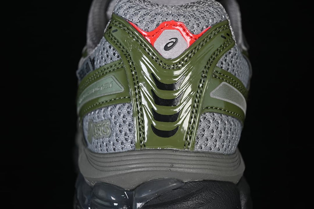 Rear view highlighting gray mesh-look panels and olive-green heel overlays.