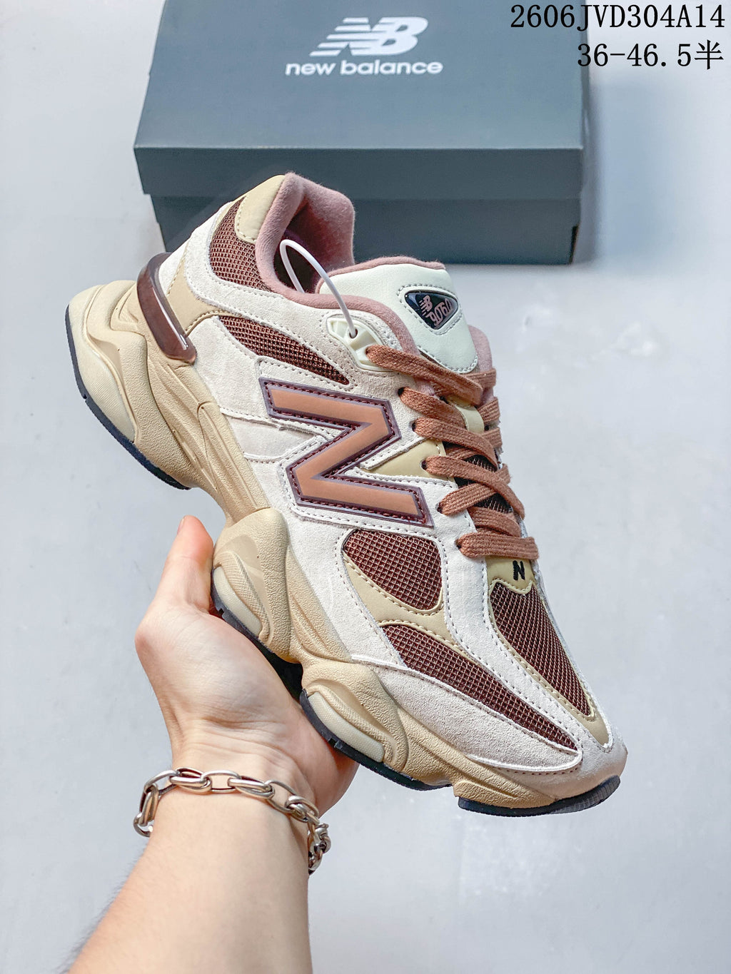 Angled side view of a cream, brown and pink New Balance 9060 sneaker