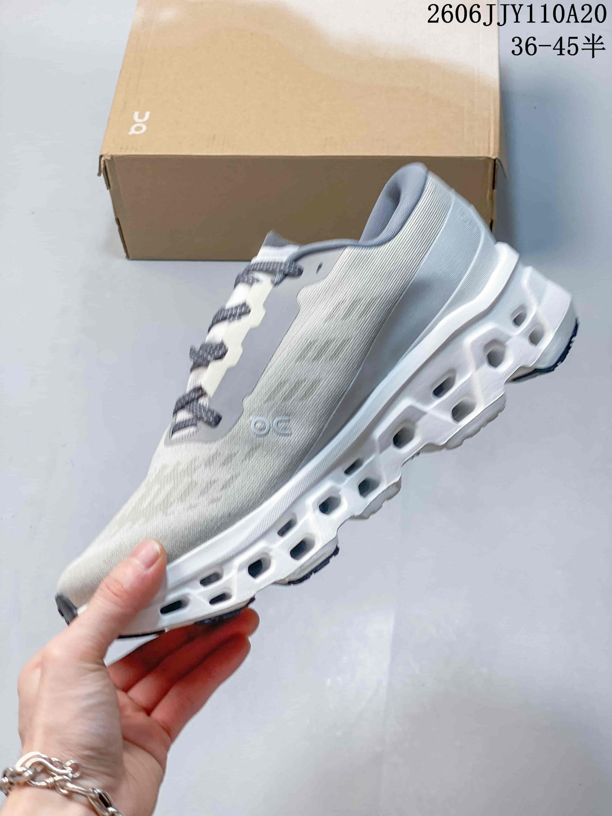 Side view of a light gray running shoe with a sculpted white sole