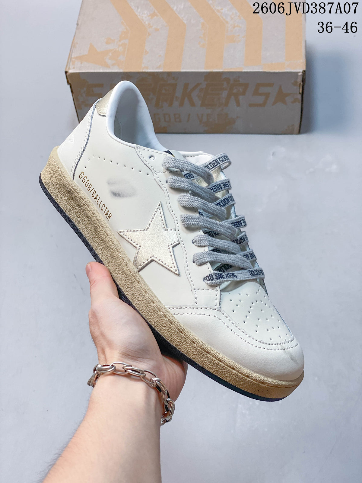 Side view of the white sneaker with silver star detail and printed side lettering