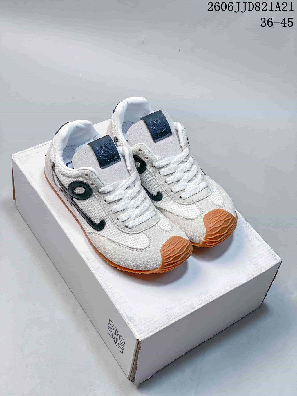 Pair of white mesh sneakers with dark side detailing and gum-tone outsoles