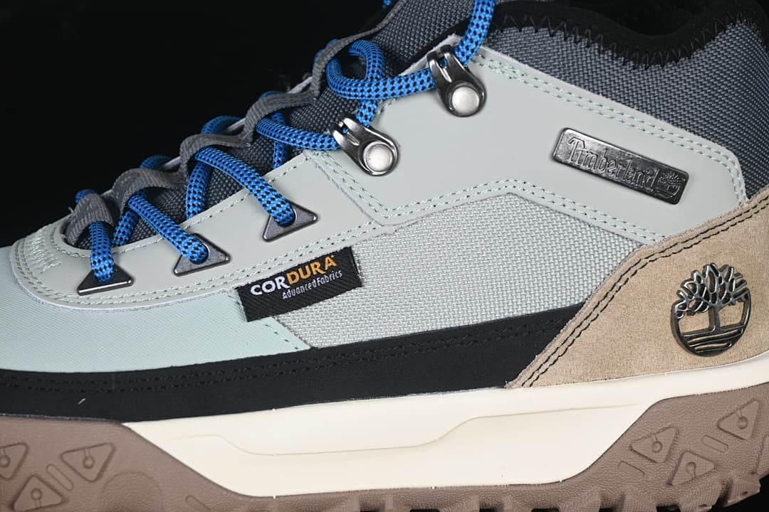 Close-up of the side panels, blue laces, metal hooks, and brand badges