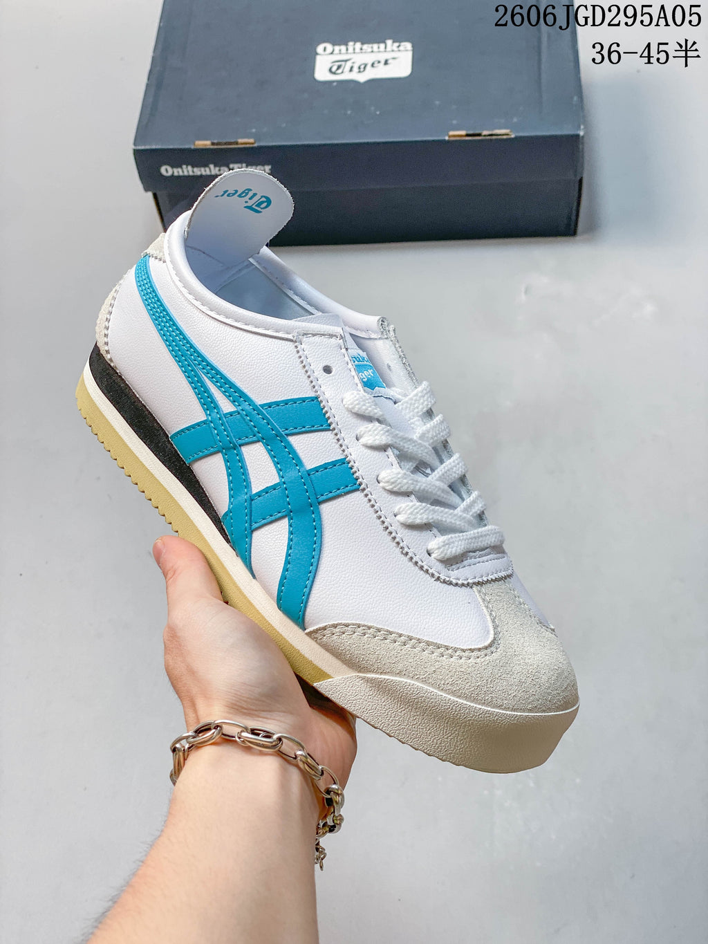 White low-top sneaker with pale gray overlays and a gum-colored sole