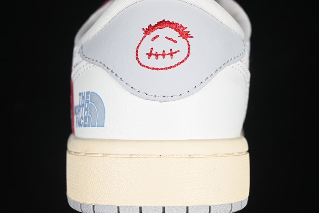 Rear heel detail with red embroidered motif and blue side branding.