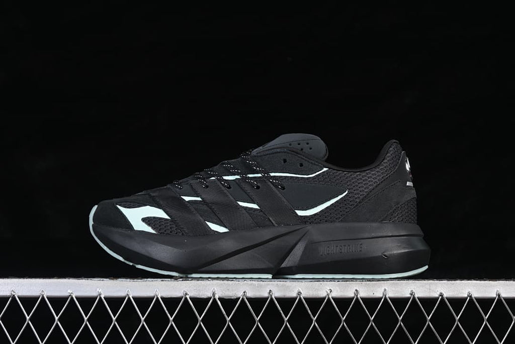 Opposite side view of the black Adidas Lightblaze shoe with pale mint details