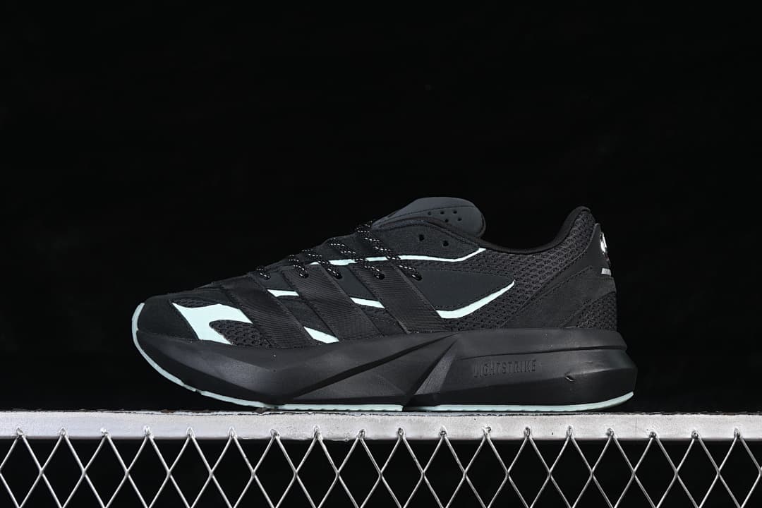 Opposite side view of the black Adidas Lightblaze shoe with pale mint details