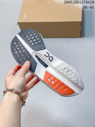 Outsole view of the On Cloudboom Volt showing gray and orange tread sections.