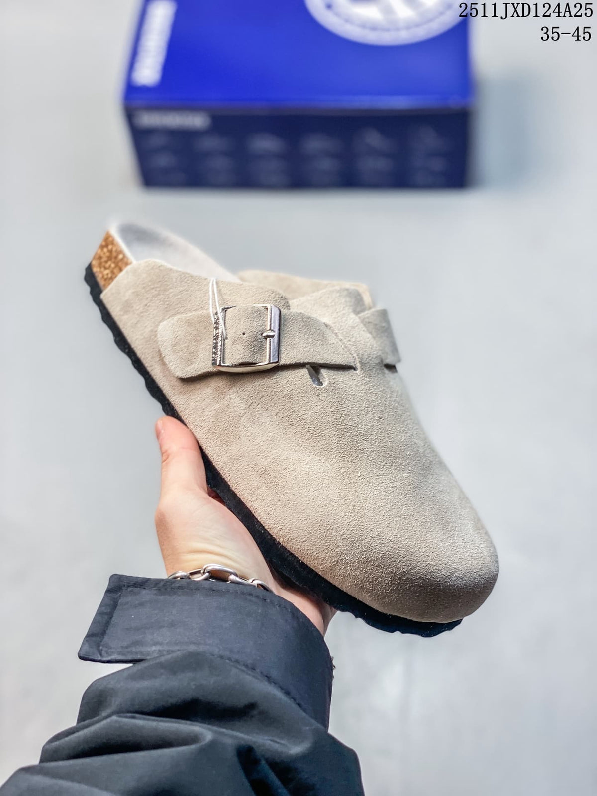Angled side view of a taupe closed-toe clog with an adjustable metal buckle