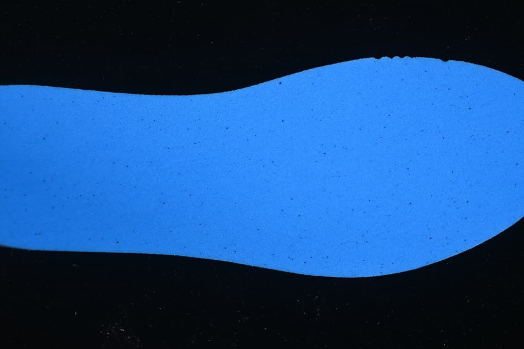 Blue outsole or insole surface shown against a dark background