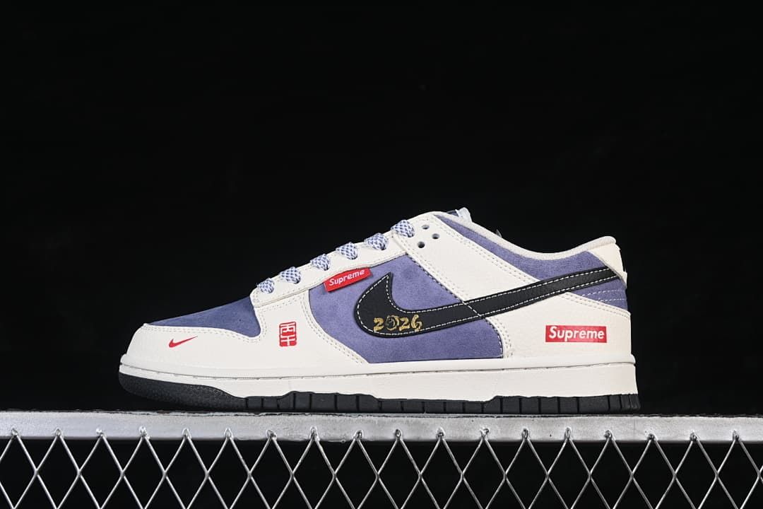 Side view of a blue, white, and black low-top sneaker with red Supreme-branded details.