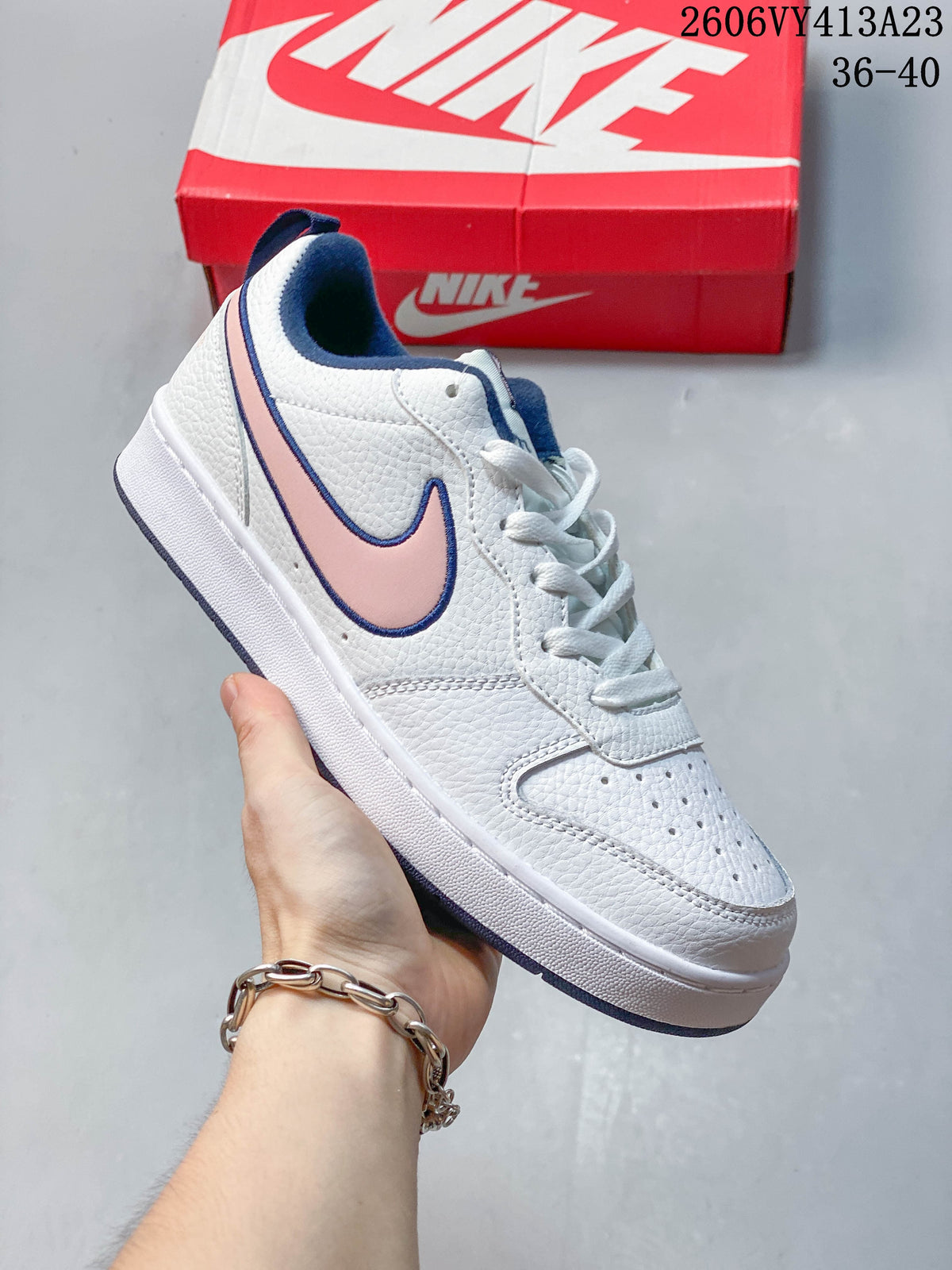 Side view of a white NikeCourt Borough 2 Low sneaker with pink and navy accents
