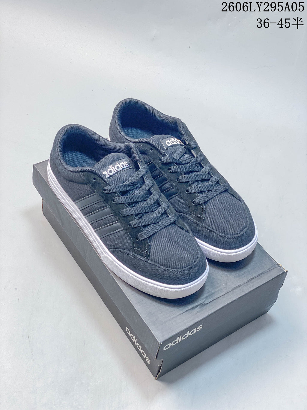 Pair of charcoal gray adidas low-top sneakers with tonal three-stripe details.