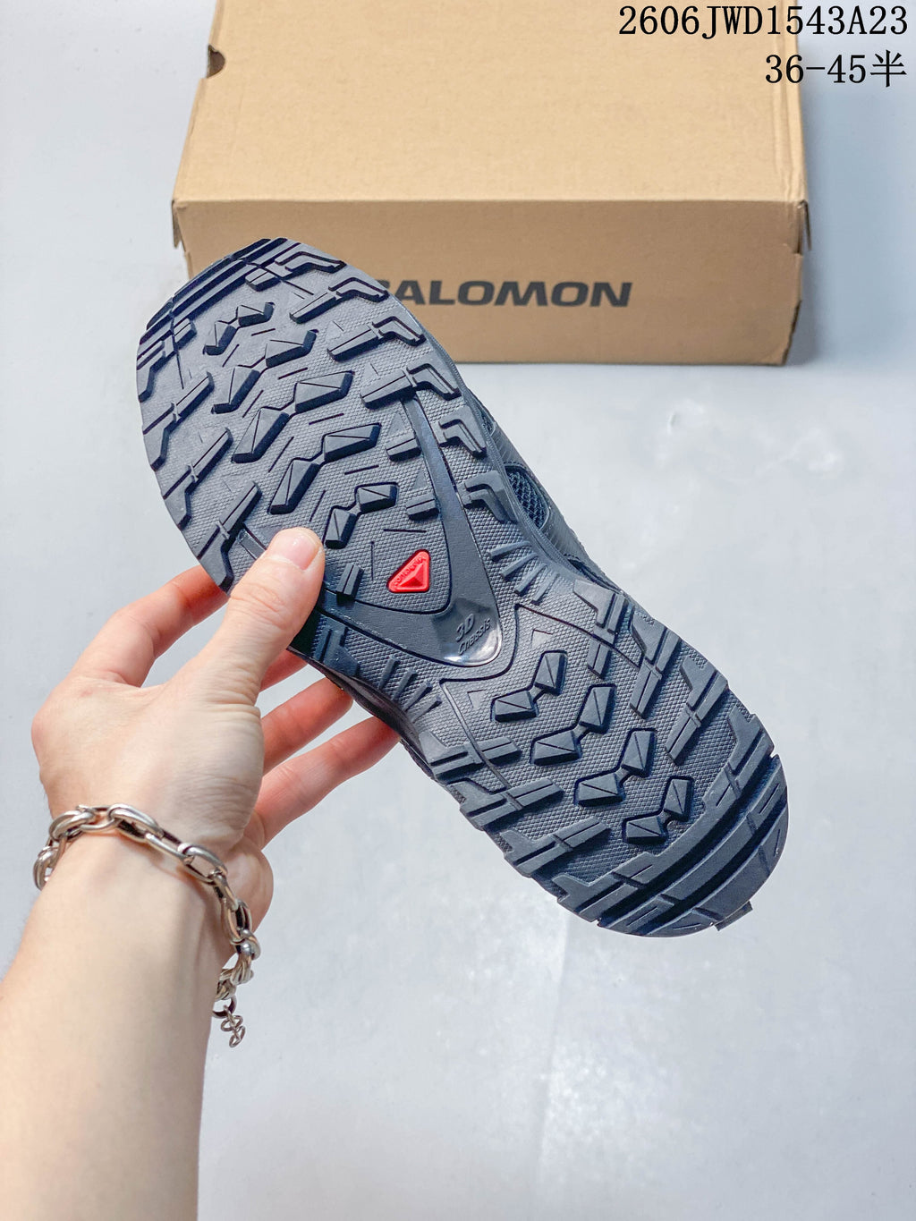 Close-up of the patterned outsole on a dark gray Salomon shoe.