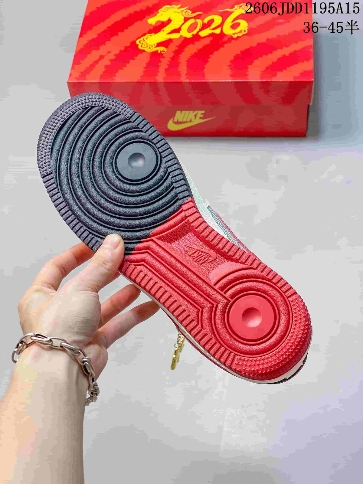View of the Nike Air Force 1 Low outsole, with navy and red sections and a red 2026 shoe box in the background