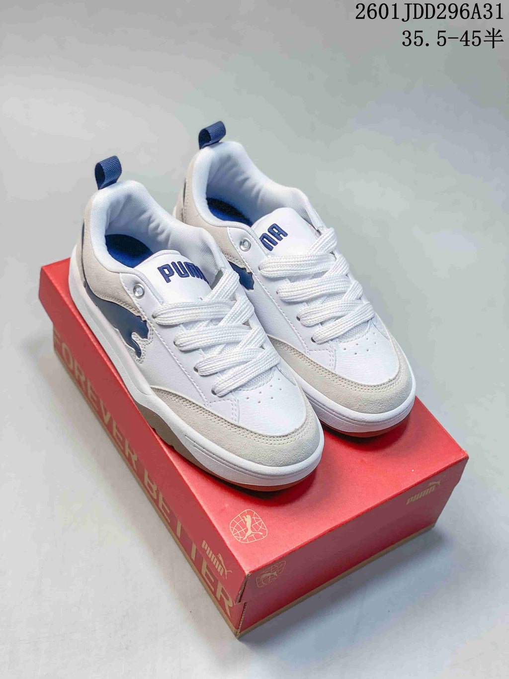 Pair of white PUMA 180 sneakers with gray overlays, navy accents, and gum-tone soles
