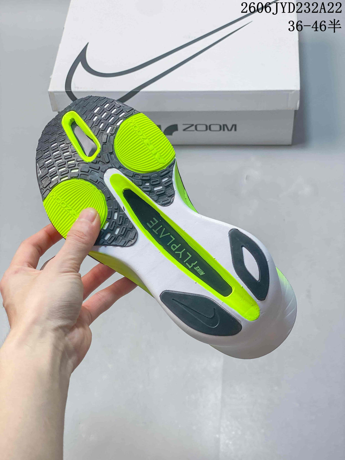 Underside of the Nike running shoe showing a dark outsole and bright green sections