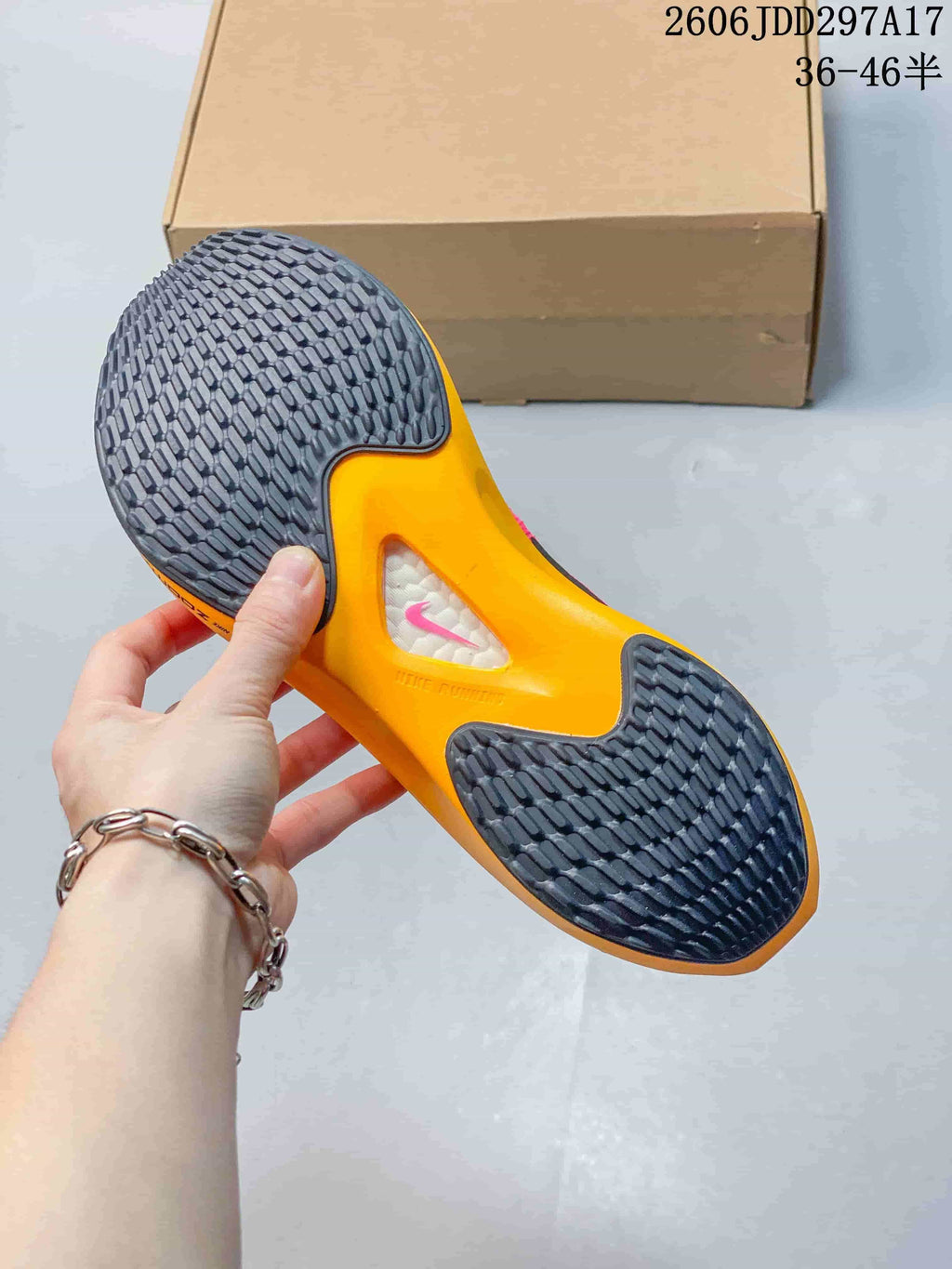 Underside of a Nike Zoom Fly 5 shoe showing patterned dark outsole and orange midsole