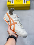 White low-top sneaker with orange side stripes and orange outsole accents