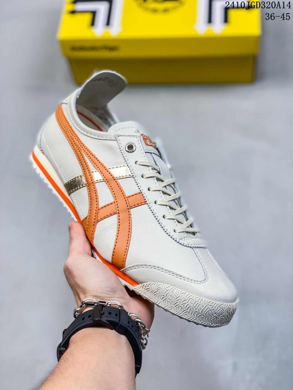 White low-top sneaker with orange side stripes and orange outsole accents
