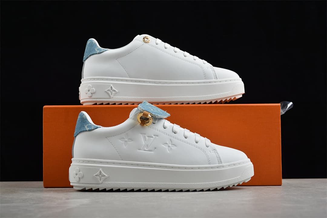 Pair of white platform sneakers displayed against an orange box