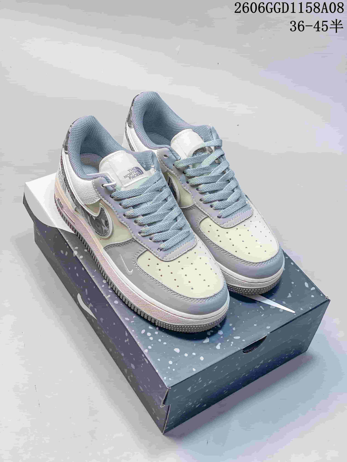 Pair of cream and gray low-top sneakers with camouflage-patterned side accents, shown from above on a shoe box