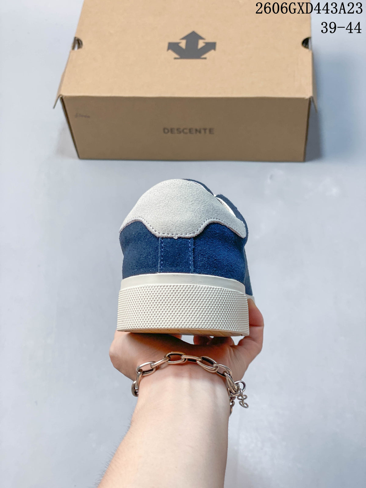 Rear view of the navy sneaker showing its light-colored heel detail and textured sole.