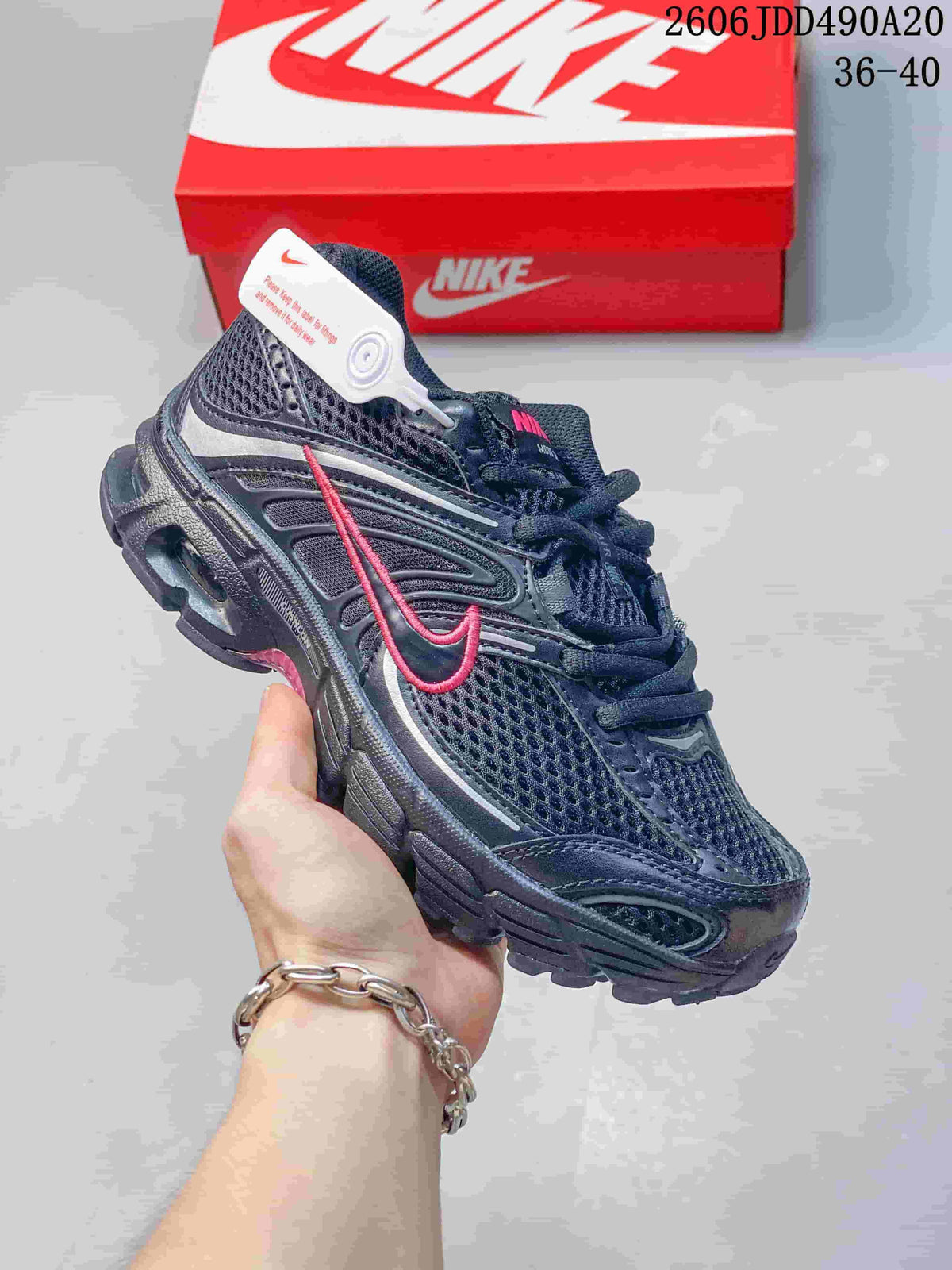 Dark Nike Air Max Moto 2K sneaker with a pink Swoosh accent