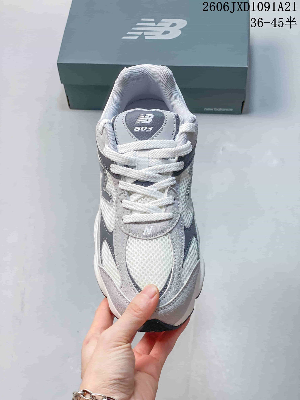 Front view of a gray and white New Balance sneaker with white laces