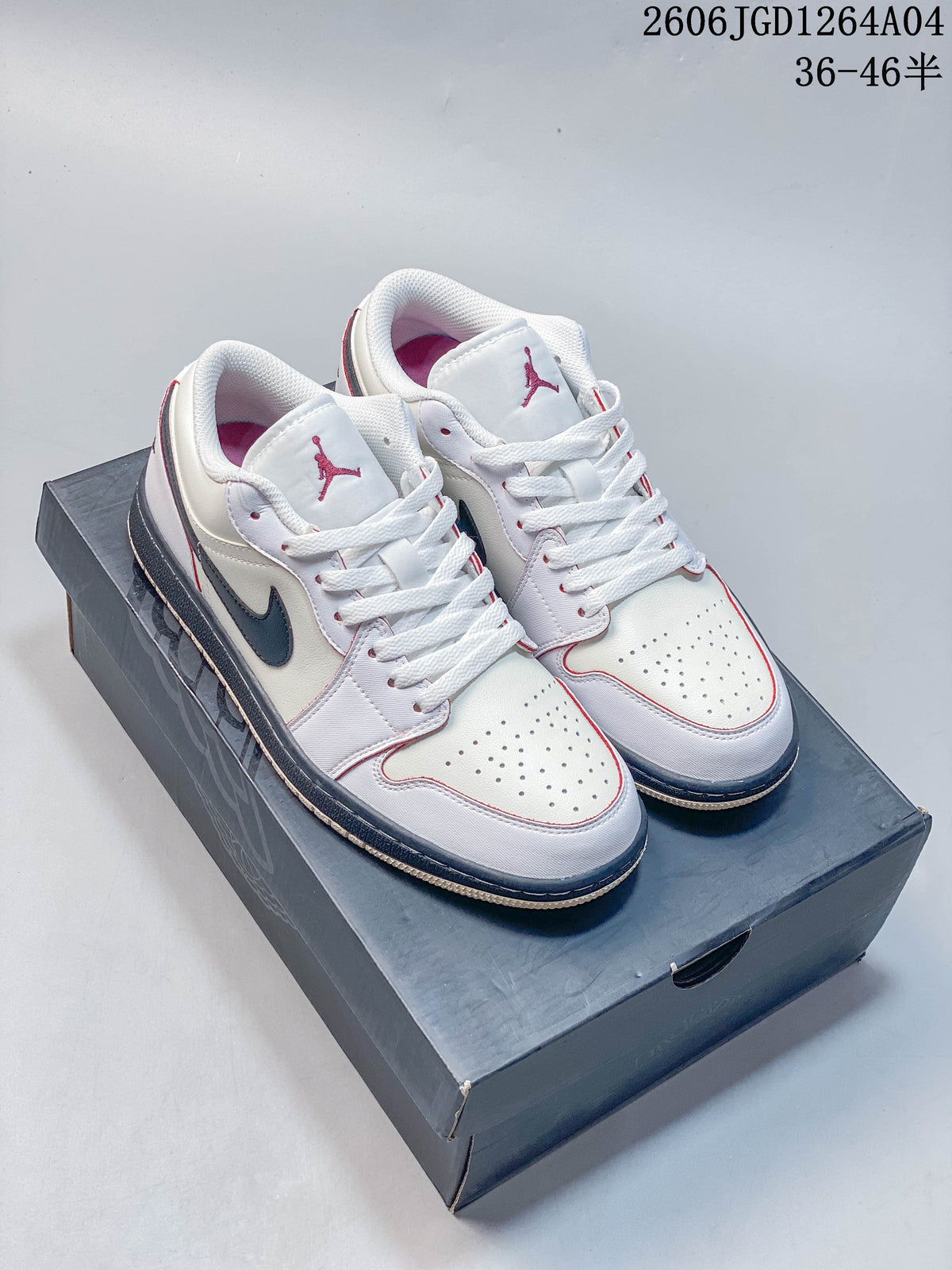 Pair of white low-top sneakers with dark side accents and red detailing