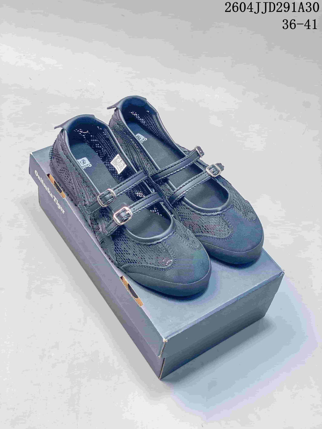 Pair of dark gray Mary Jane-style shoes with two buckle straps on a box
