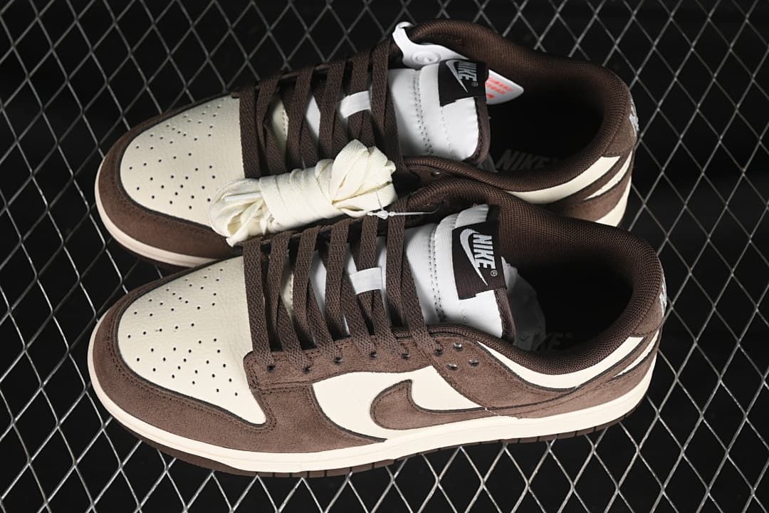 Pair of brown and off-white low-top sneakers with spare light-colored laces