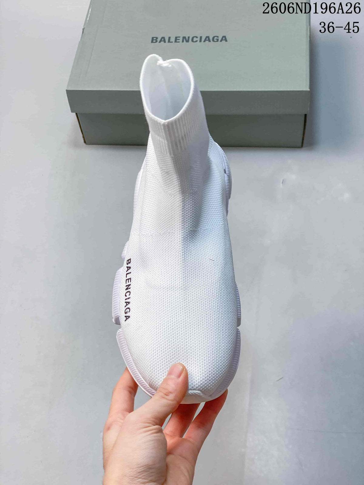 Front view of the white sneaker showing its sock-like ankle opening.