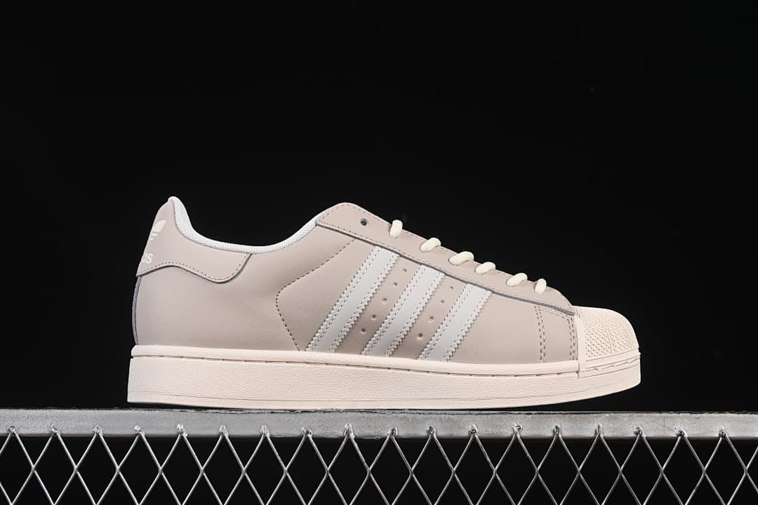 Side profile showing the beige upper, white stripes and off-white sole.