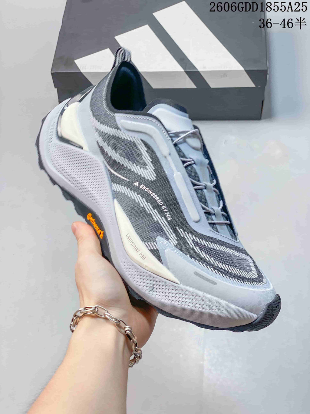 Side view of a gray Adidas Holo Peak shoe with blue accents and a rugged outsole