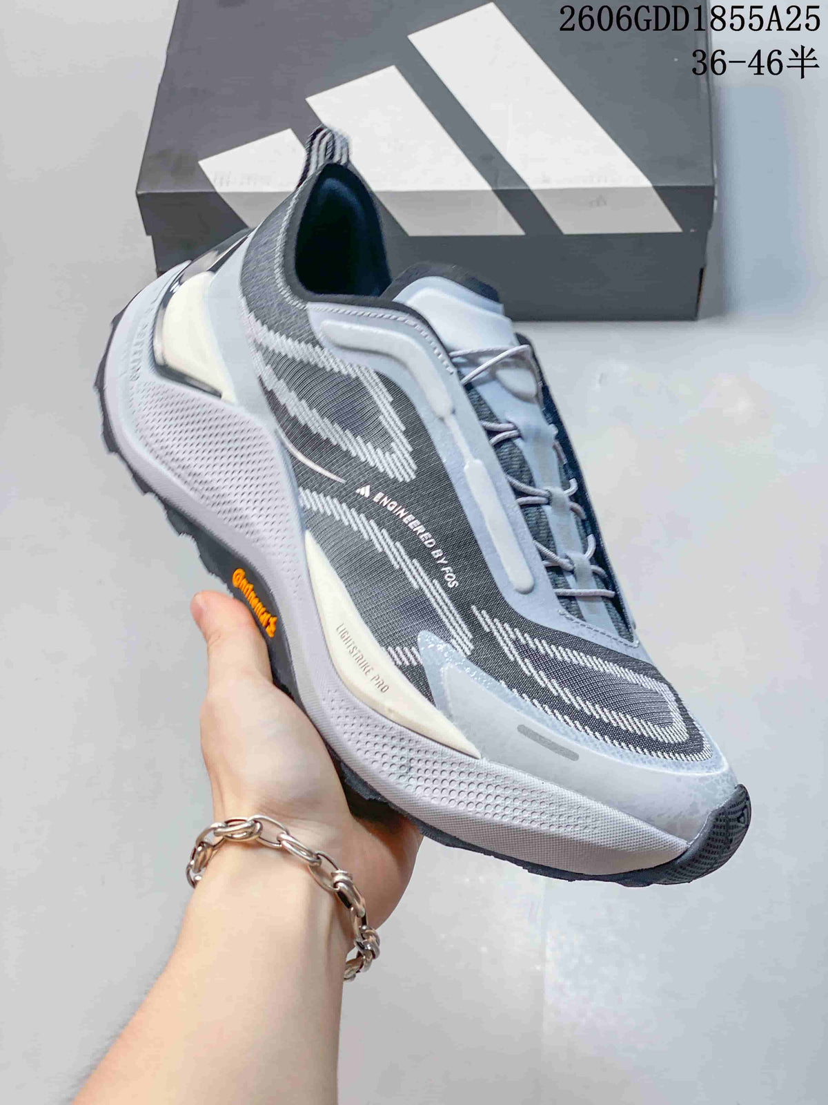 Side view of a gray Adidas Holo Peak shoe with blue accents and a rugged outsole