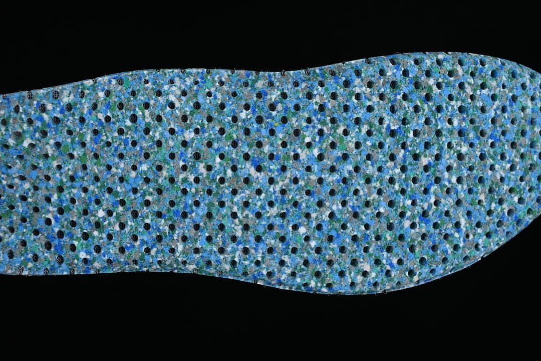 Close-up of the dotted blue-green underside of a shoe insole.