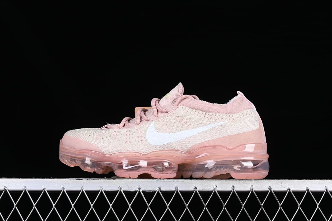 Side view of the light pink and cream shoe with white Swoosh and transparent pink-toned sole.
